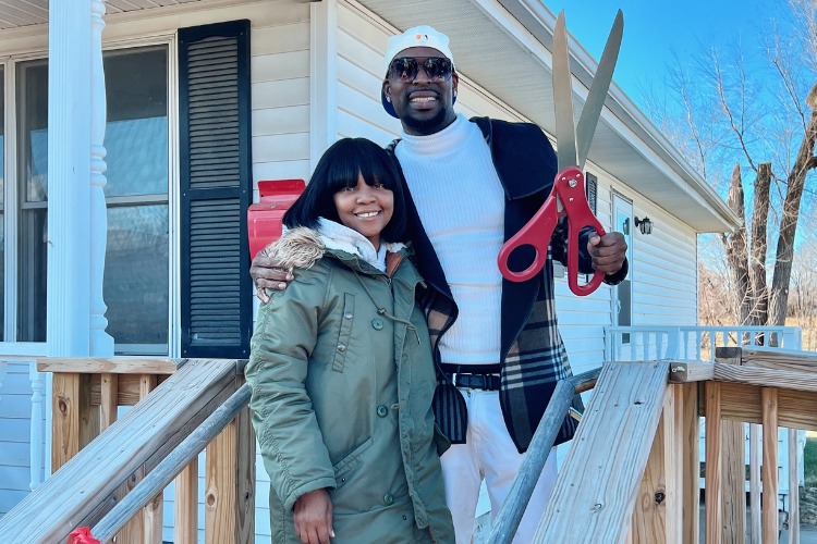 Fontroy, right and his partner, outside his mother’s former home that now belongs to him.